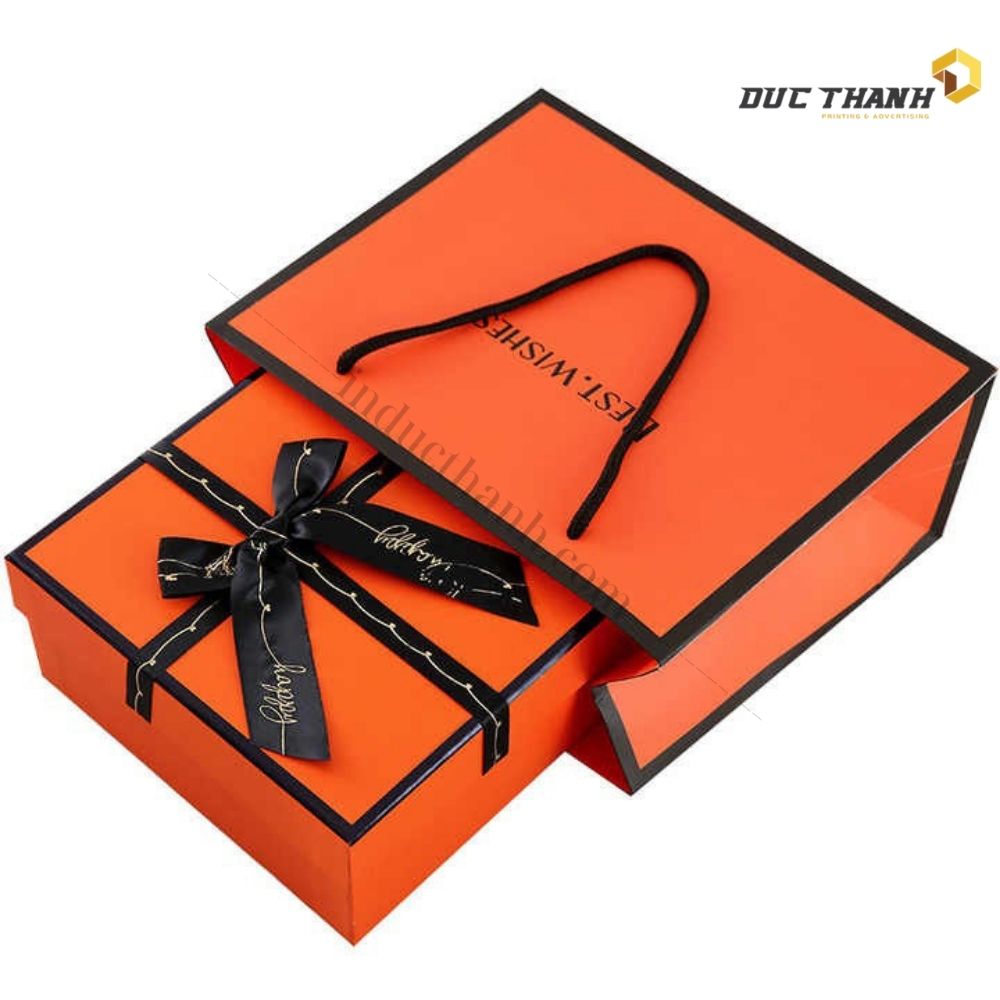 Mẫu hộp giấy đựng quần áo màu cam có dây ruy băng đen