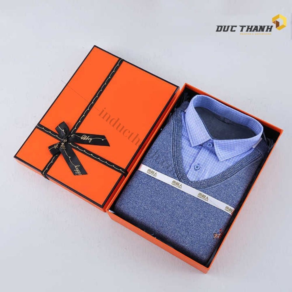 Mẫu hộp giấy đựng quần áo màu cam có dây ruy băng đen